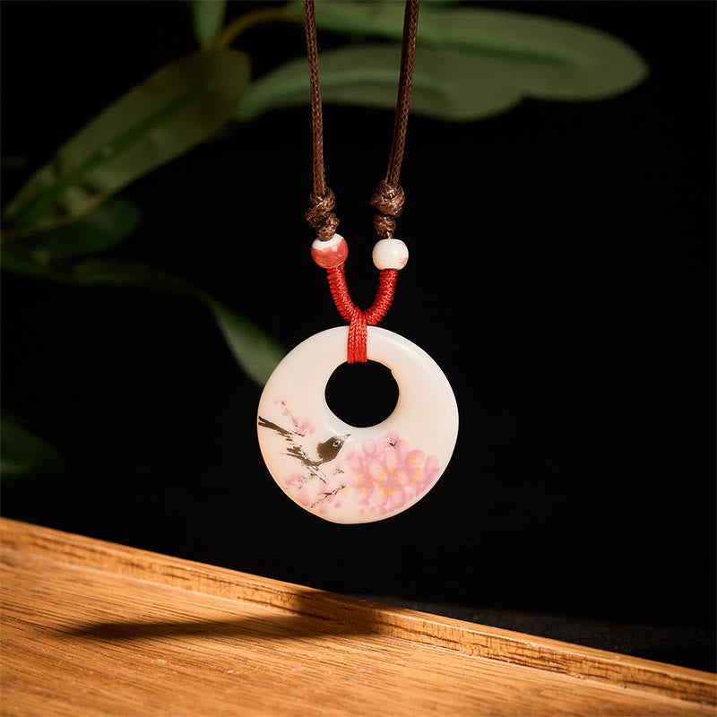 Ceramic Peony & Lotus Pendant – Cherry blossom bird motif on cream disc with red cord, porcelain pendant