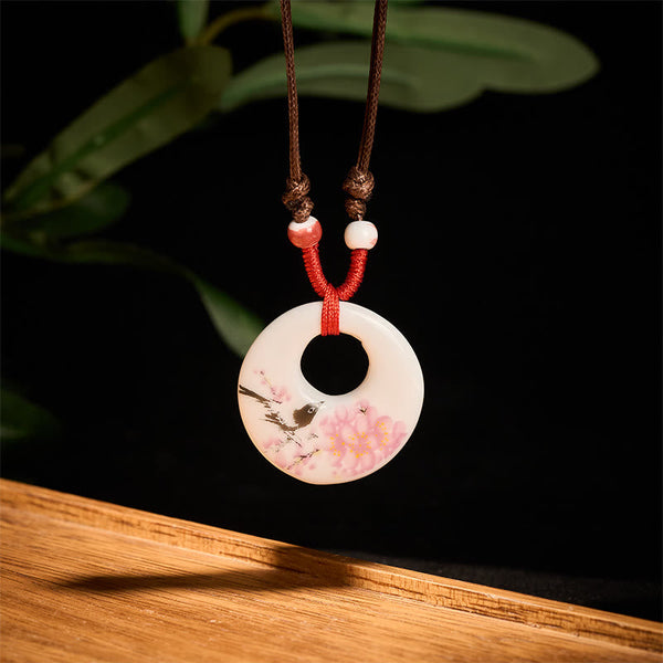 Ceramic Peony & Lotus Pendant – Cherry blossom bird motif on cream disc with red cord, porcelain pendant