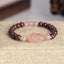 Garnet Strawberry Quartz Pixiu Bracelet – close-up on beige linen with gold spacers, garnet healing jewelry