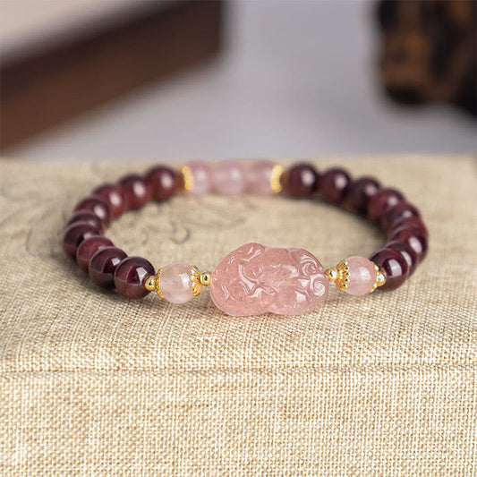Garnet Strawberry Quartz Pixiu Bracelet – close-up on beige linen with gold spacers, garnet healing jewelry