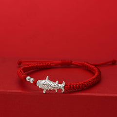 999 Silver Koi Fish Red String Bracelet – silver koi fish charm on handwoven red cord on red background, lucky jewelry
