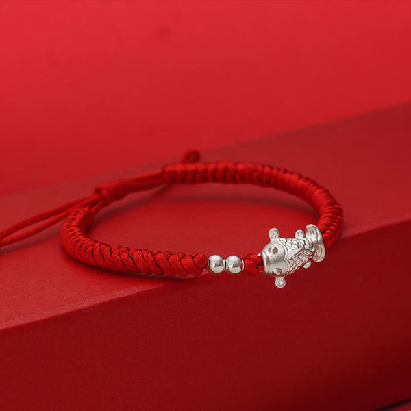 999 Silver Koi Fish Red String Bracelet – red cord bracelet with silver koi fish charm on red geometric display platform