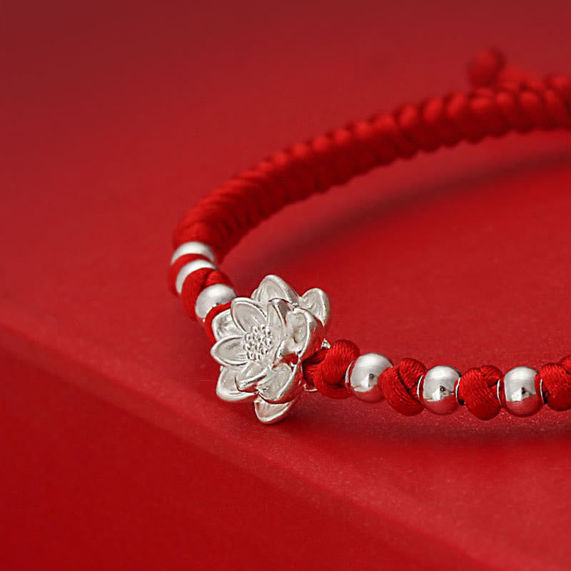 Sterling Silver Lotus Red String Luck Bracelet – tight crop on silver lotus charm with shallow depth of field, artisan