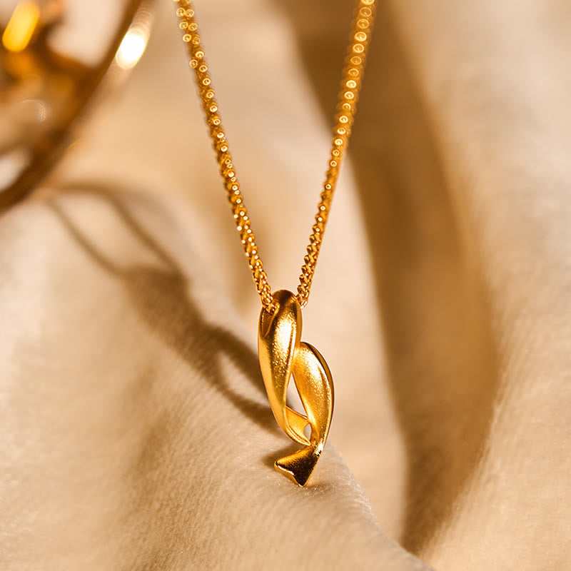 Double Koi Fish Gold Necklace Pendant – pendant on cream fabric with bokeh lights, 24K gold plated jewelry