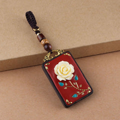 Ebony Koi Fish Fu Character Keychain – single red lacquer rose pendant with gold stem and turquoise inlay on kraft paper