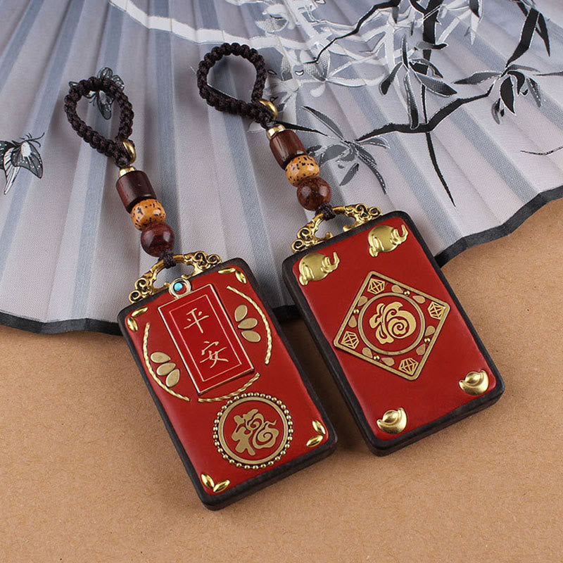 Ebony Koi Fish Fu Character Keychain – two red lacquer pendants with peace and Fu symbols on ink-wash bamboo fan background