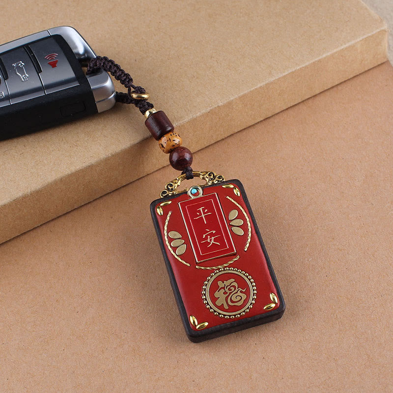 Ebony Koi Fish Fu Character Keychain – red lacquer peace amulet with gold Fu symbol attached to car key fob on kraft paper