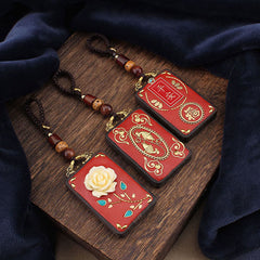 Ebony Koi Fish Fu Character Keychain – three red lacquer pendants with koi, rose, and fortune symbols on wood surface