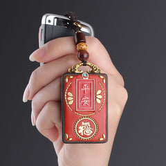 Ebony Koi Fish Fu Character Keychain – hand holding red amulet with peace and fortune characters on car key fob, gray bg