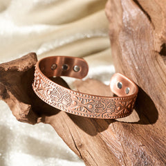 Tree of Life Copper Cuff Bracelet – warm sunlight on wooden prop showing texture, good luck bracelet
