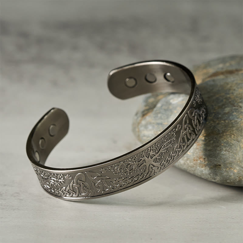 Tree of Life Copper Cuff Bracelet – side view resting on gray stone showing detail, adjustable bangle