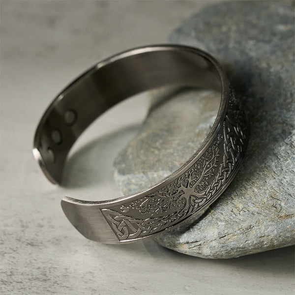 Tree of Life Copper Cuff Bracelet – angled view on stone prop highlighting tree pattern, magnetic bracelet