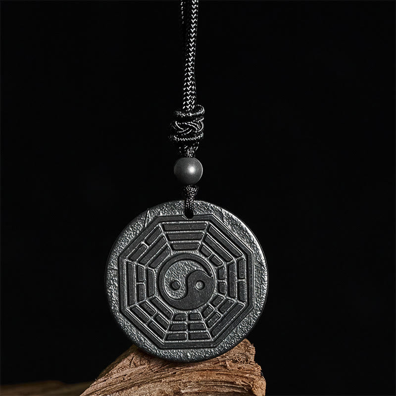 Shungite Stone Yin Yang Bagua Necklace - front on dark wood, feng shui jewelry