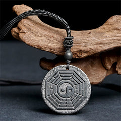 Shungite Stone Yin Yang Bagua Necklace - angled on driftwood, bagua amulet