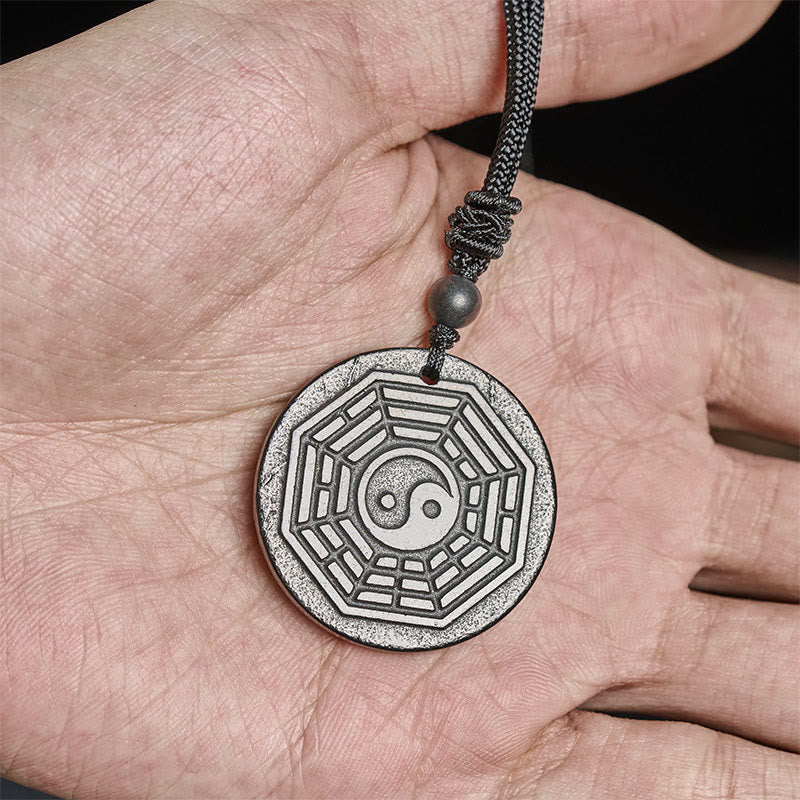 Shungite Stone Yin Yang Bagua Necklace - held in hand showing size, bagua necklace