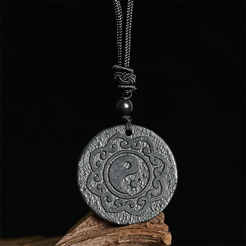 Shungite Yin Yang Pendant – close-up on black backdrop, carved yin yang talisman