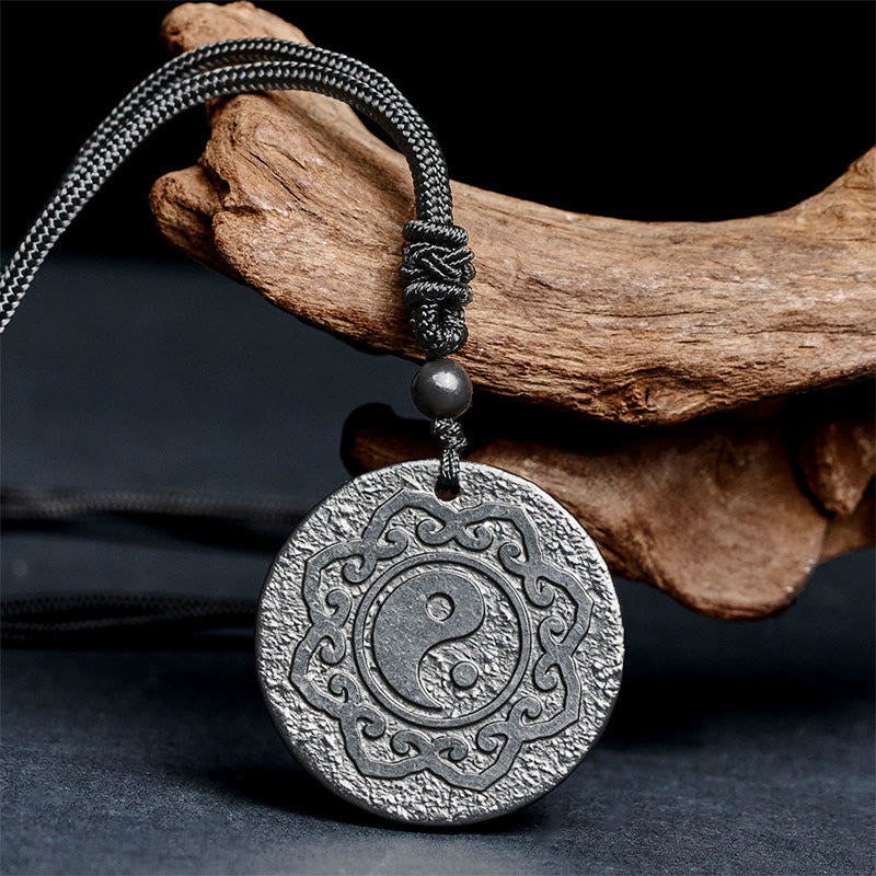 Shungite Yin Yang Pendant – angled view on dark wood, grounding stone jewelry