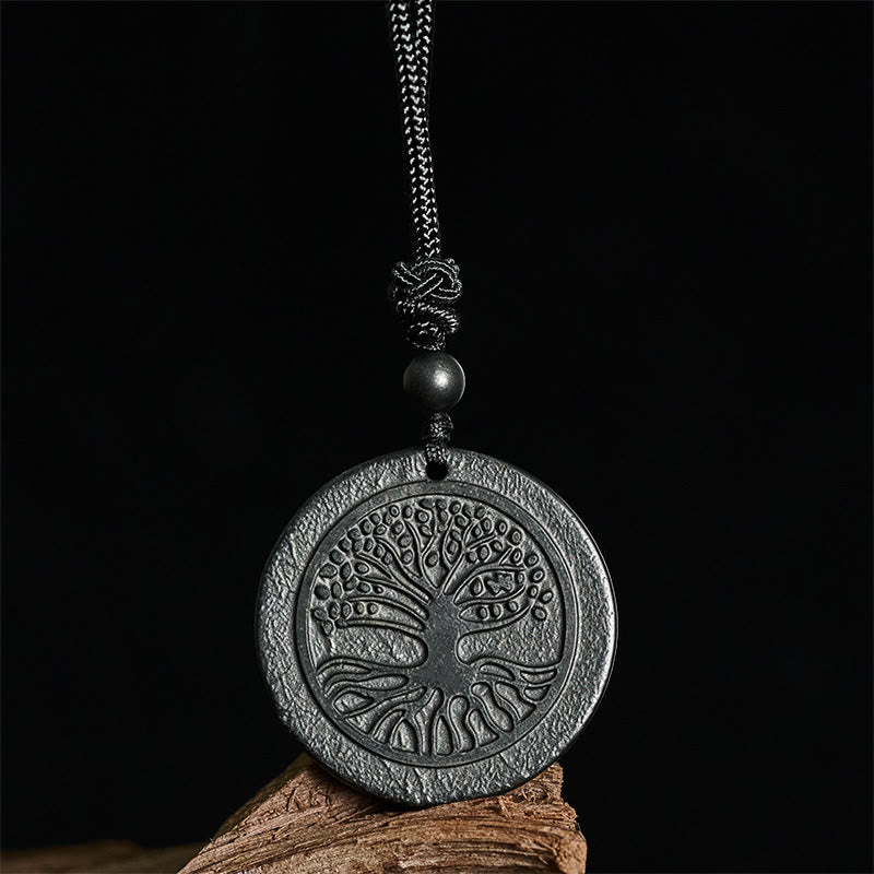 Tree of Life Shungite Stone Necklace – pendant on wood against dark background, grounding stone necklace