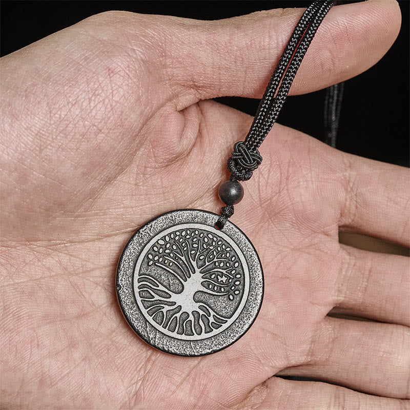 Tree of Life Shungite Stone Necklace – held in hand showing scale and carved tree design, natural stone pendant