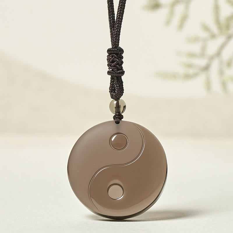 Ice Obsidian Yin Yang Pendant – front view on soft cream background, obsidian healing jewelry