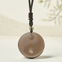 Ice Obsidian Yin Yang Pendant – front view on soft cream background, obsidian healing jewelry