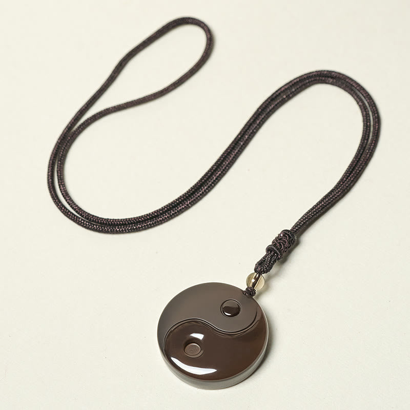 Ice Obsidian Yin Yang Pendant – flat lay on white, braided cord crystal talisman
