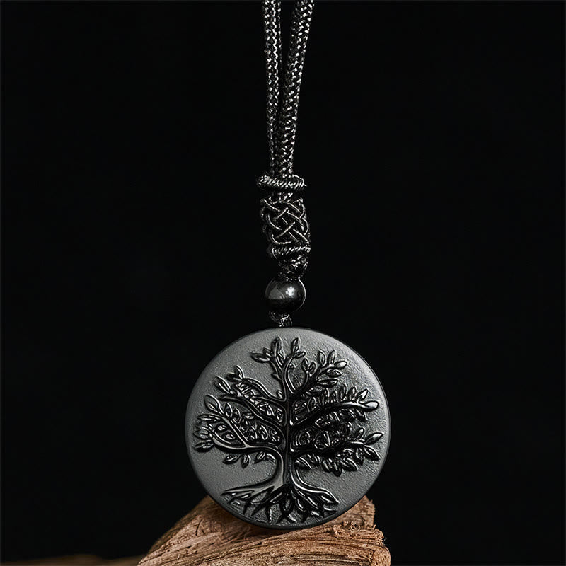 Tree of Life Black Obsidian Necklace – pendant displayed on wood against black background, healing crystal necklace