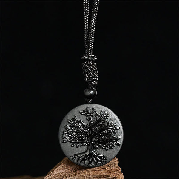 Tree of Life Black Obsidian Necklace – pendant displayed on wood against black background, healing crystal necklace