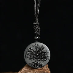 Tree of Life Black Obsidian Necklace – pendant displayed on wood against black background, healing crystal necklace