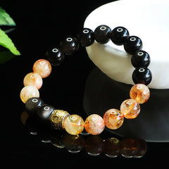 Obsidian Citrine Mantra Bracelet - Glossy obsidian and citrine beads with gold charm on white ceramic stand, beaded bracelet