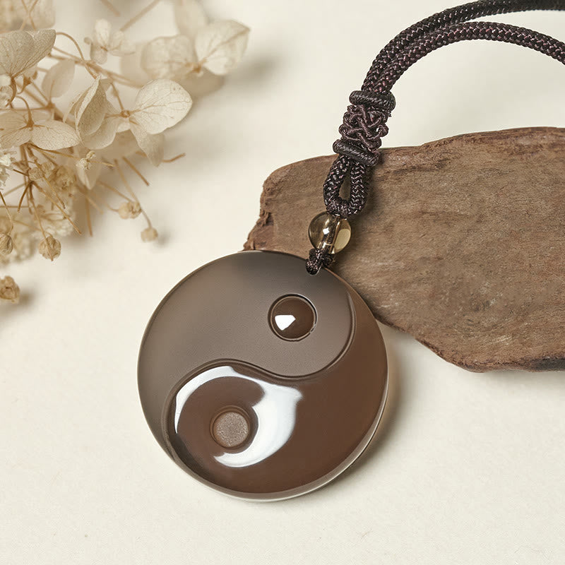 Black Obsidian Nine-Character Mantra Necklace – Yin-Yang obsidian pendant styled with wood and flowers, natural jewelry shot