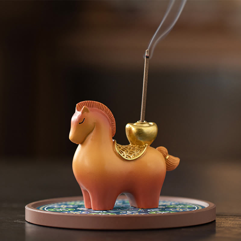 Year of Horse Ingot Incense Burner – Terracotta horse with gold saddle on blue enamel base, lit incense stick, incense burner