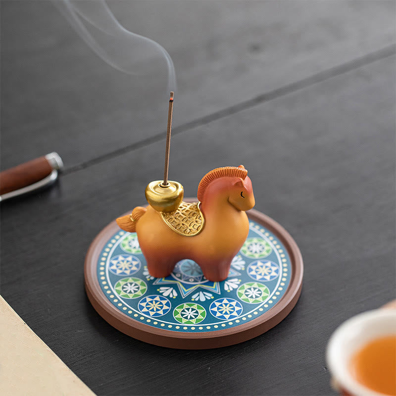 Year of Horse Ingot Incense Burner – Amber ceramic horse with gold saddle on mandala base, smoke from lit stick, incense burner