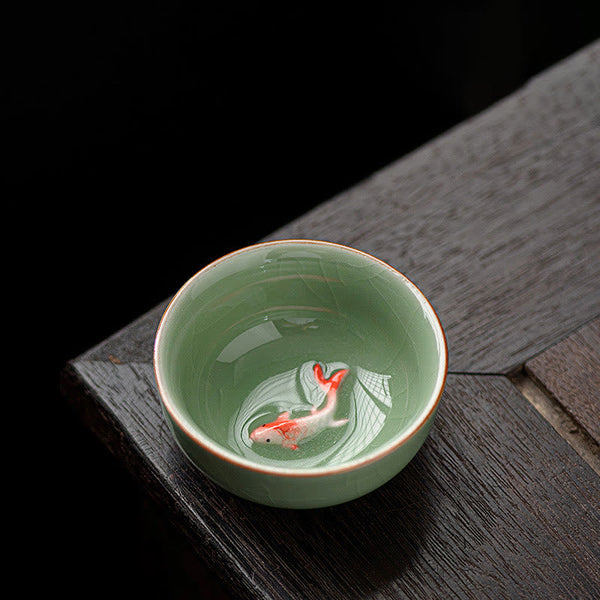 Hand Painted Koi Fish Ceramic Teacup – overhead view of orange koi and water ripples inside celadon cup