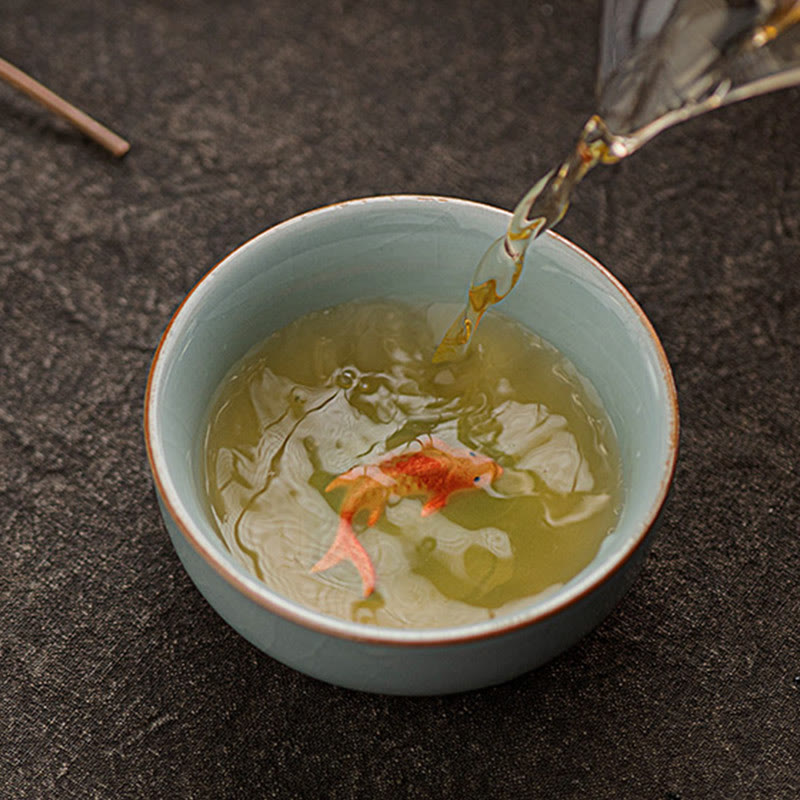 Hand Painted Koi Fish Ceramic Teacup – tea pouring into cup revealing koi through amber liquid, tea ceremony