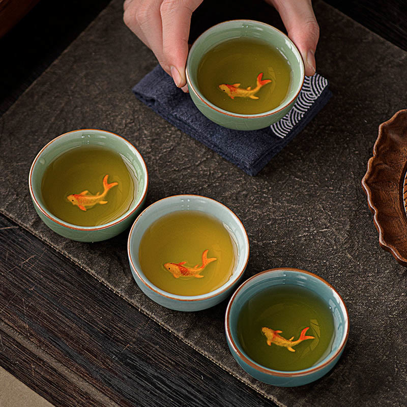 Hand Painted Koi Fish Ceramic Teacup – four cups with tea and koi on wave cloth, gongfu tea ceremony set