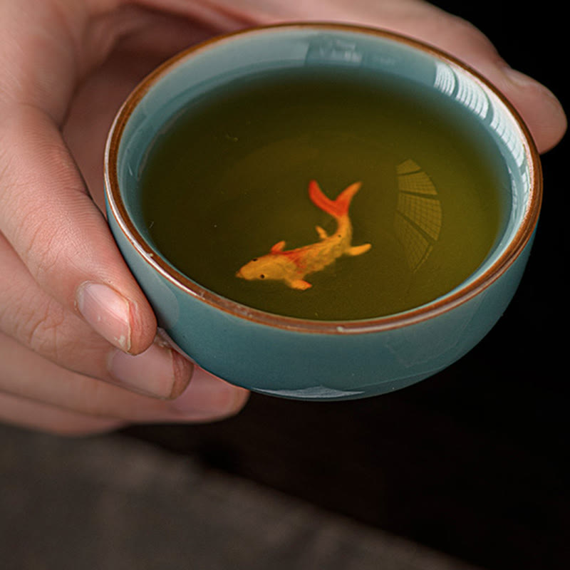Hand Painted Koi Fish Ceramic Teacup – hand holding cup with koi fish illusion in tea, ceramic gongfu cup