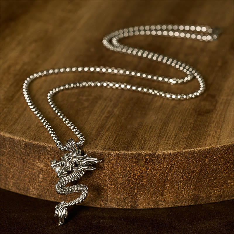 Copper Dragon Necklace – Dragon on rustic wood slice, warm lighting, artisanal