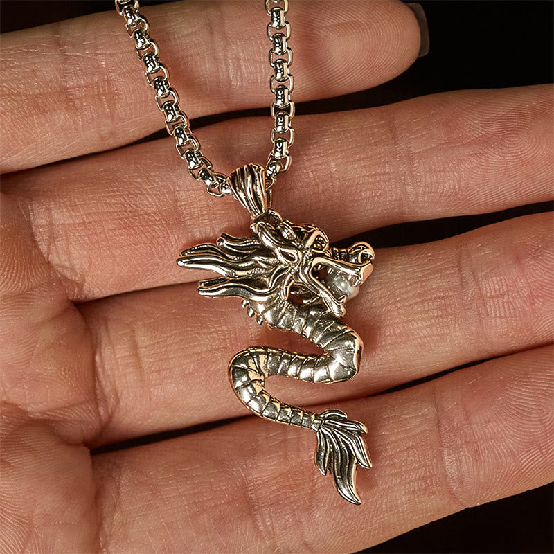 Copper Dragon Necklace – Dragon pendant held in hand, black background, tactile