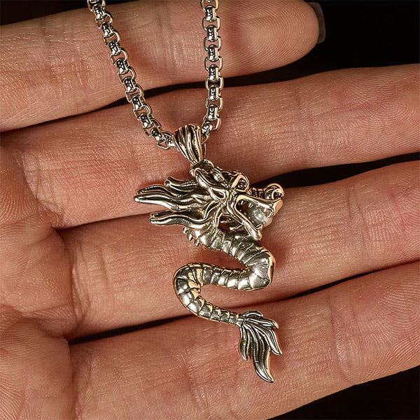 Copper Dragon Necklace – Dragon pendant held in hand, black background, tactile