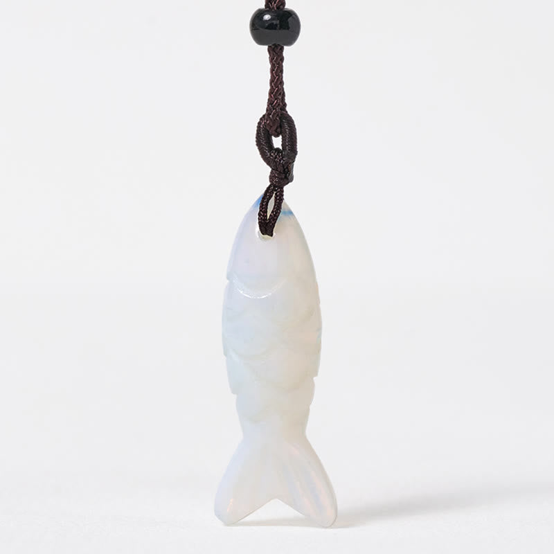 Koi Fish Crystal Necklace Pendant – pink rose quartz pendant diagonal on rustic wood, carved fish gemstone