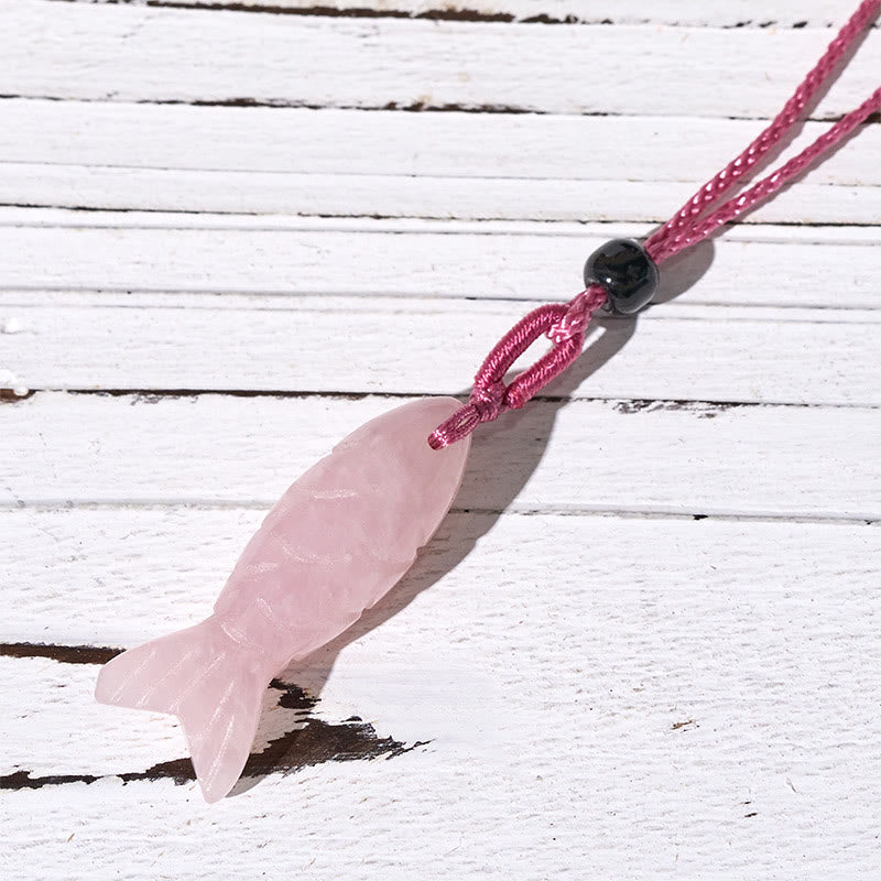 Koi Fish Crystal Necklace Pendant – pink rose quartz koi on weathered wood diagonal, carved fish pendant