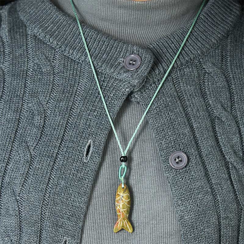 Koi Fish Crystal Necklace Pendant – amethyst pendant held in fingers crystal banding visible, purple gemstone