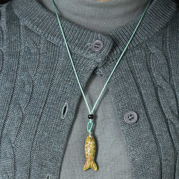 Koi Fish Crystal Necklace Pendant – amethyst pendant held in fingers crystal banding visible, purple gemstone