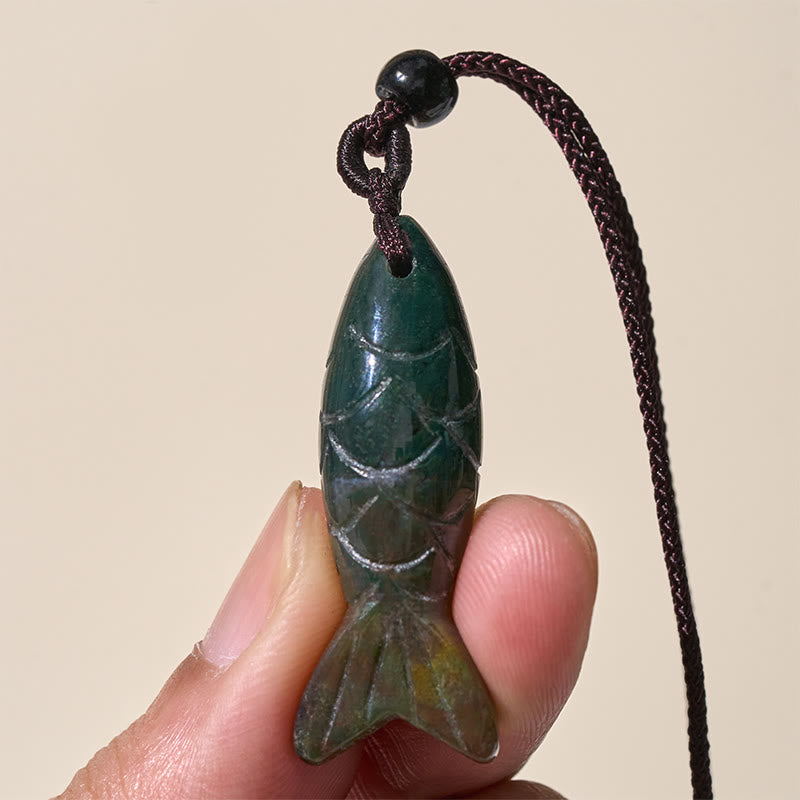 Koi Fish Crystal Necklace Pendant – green aventurine koi held in fingers three-quarter view, healing jewelry