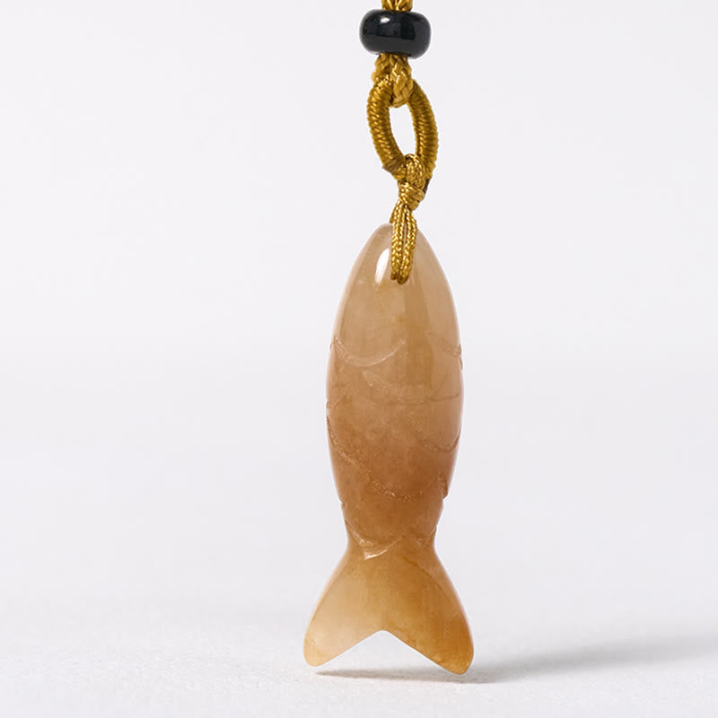 Koi Fish Crystal Necklace Pendant – rose quartz fish pendant diagonal angle on rustic wood, pink gemstone