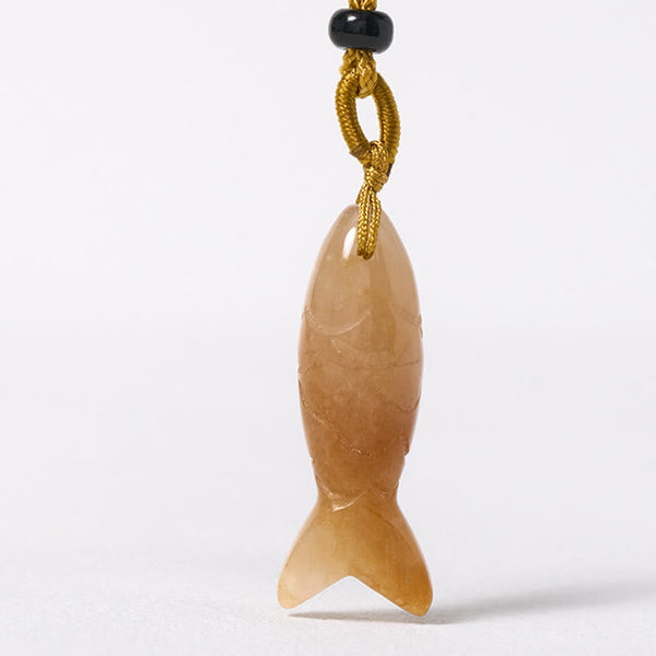 Koi Fish Crystal Necklace Pendant – rose quartz fish pendant diagonal angle on rustic wood, pink gemstone