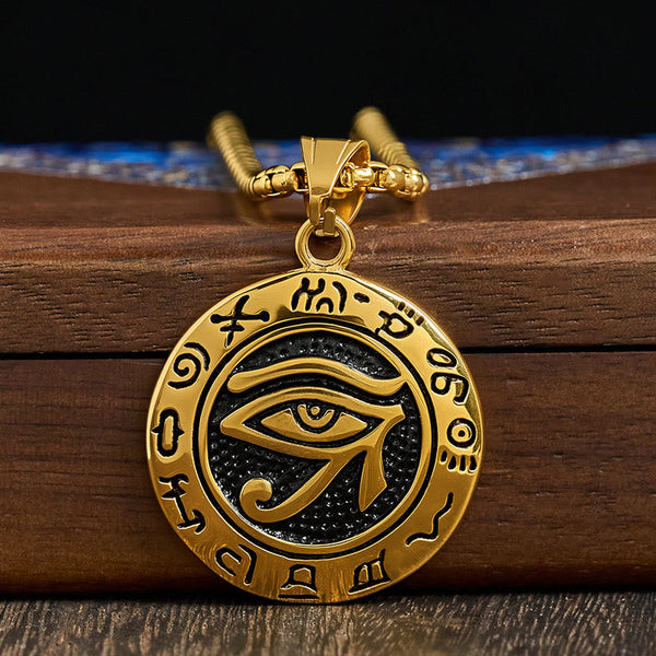Gold Titanium Necklace – Gold Egyptian eye pendant with black background on stacked wood, chain detail