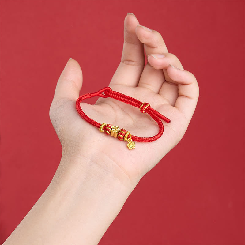 Fu Character Red String Bracelet – resting on palm showing gold cylindrical beads and disc charm, hand model, Chinese lucky bracelet