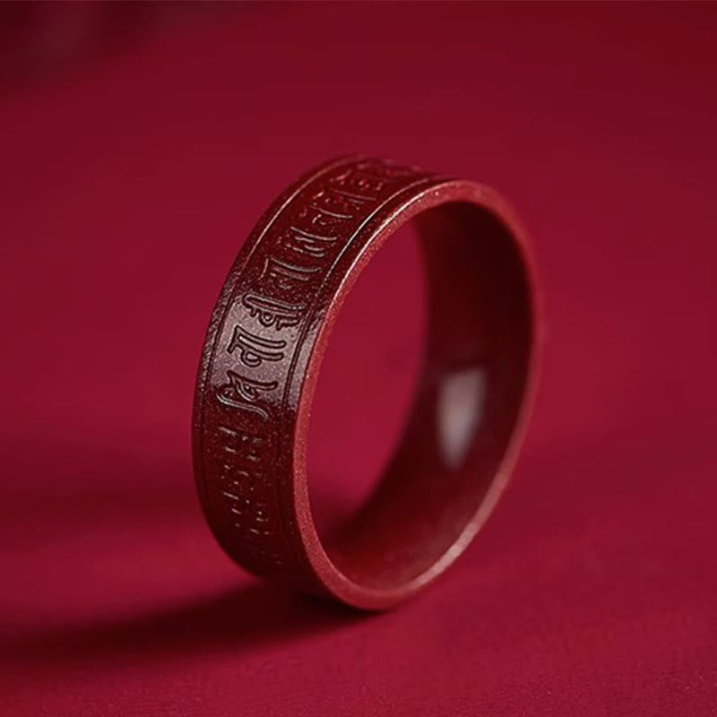 Cinnabar Heart Sutra Om Mani Padme Hum Blessing Ring – three-quarter view on crimson backdrop highlighting Sanskrit engraving, mantra ring